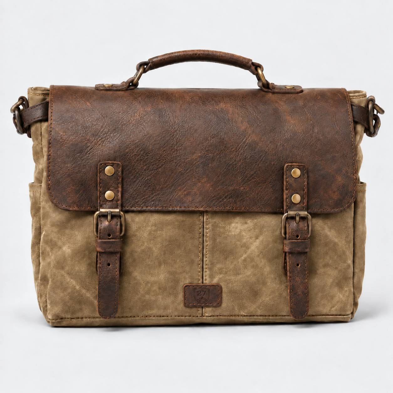 A rustic leather and canvas messenger bag with a distressed brown leather top flap, buckle straps, a top handle, and a tan canvas body, shown against a light gray background.